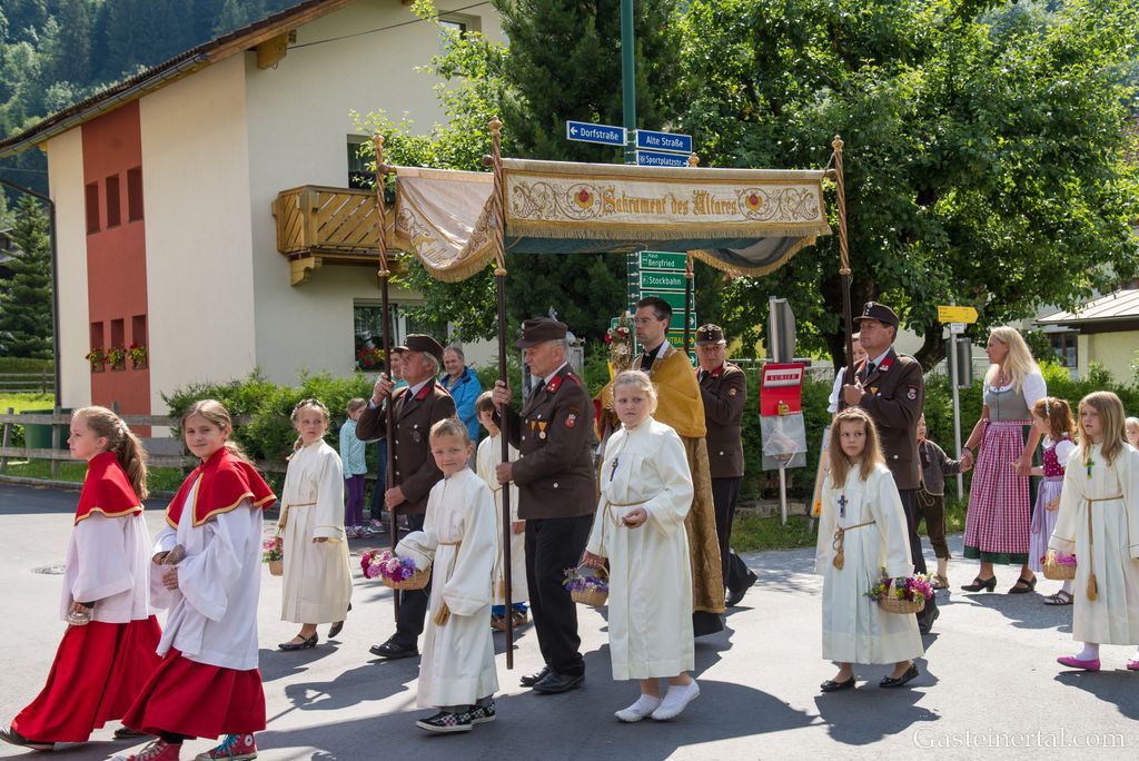 <Prozession mit Gasteiner Vereinen am Gemeindeplatz in Dorfgastein