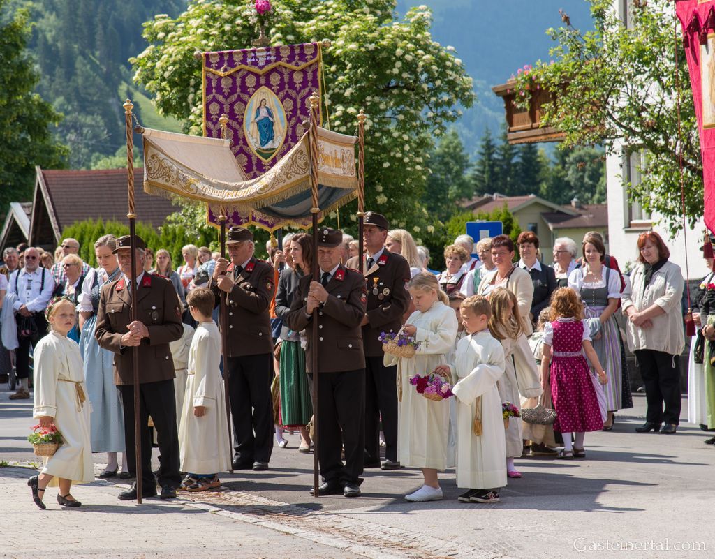 <Prozession mit Gasteiner Vereinen am Gemeindeplatz in Dorfgastein