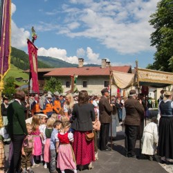 Prozession mit Gasteiner Vereinen am Gemeindeplatz in Dorfgastein